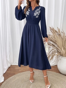 Détails de broderie florale blanche sur robe longue bleu marine à col en V et évasée