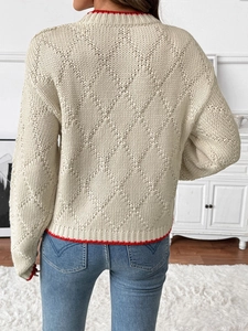 Texture de maille détaillée et bord contrasté rouge d'un pull beige à manches longues de dos