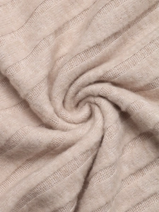 Close-up of beige ribbed knit fabric showing soft texture and high elasticity of the top