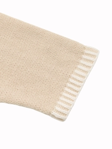 Vue macro de la manche du cardigan en tricot avec poignet côtelé blanc et texture