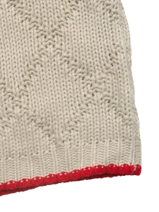 Vue détaillée du pull en maille beige avec bordure rouge contrastée et finitions