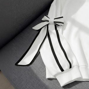White long-sleeve sweatshirt with oversized black-striped bow details and ribbed cuffs