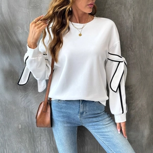 White crewneck sweatshirt featuring contrast black bow details and ribbed long sleeves