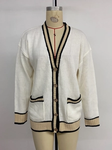Close-up of V-neck knitted cardigan with black and khaki striped edges and buttons