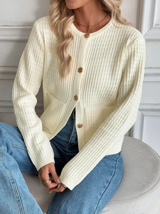 Detail of cream knit cardigan featuring vintage gold buttons and ribbed texture