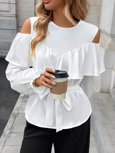 Detail of white cold-shoulder satin blouse with ruffles and a matching waist belt