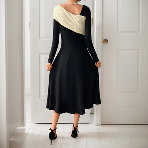 Elegant black and white contrast knit midi dress with long sleeves and irregular panels