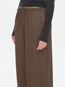 Detail view of the elastic drawstring waistband on solid dark brown wide leg casual pants