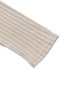 Détail des poignets en maille côtelée beige montrant la texture verticale de qualité