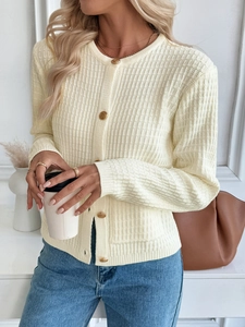 Detail of cream rib-knit cardigan featuring embossed gold metal buttons and round neck