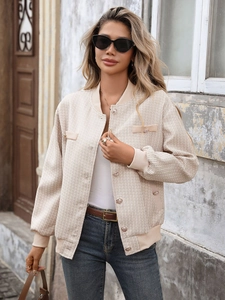 Détail de la veste en tweed avec boutons métalliques et finitions bord-côte