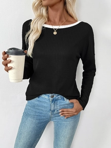 Detail of black ribbed knit long sleeve top with white boat neck contrast stitching