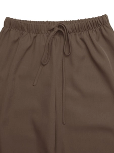 Detail view of the elastic waistband and matching drawstring on dark brown casual trousers