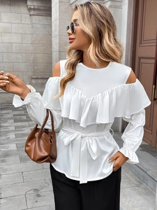 Detail of white cold-shoulder blouse with elegant ruffles and a waist tie for women
