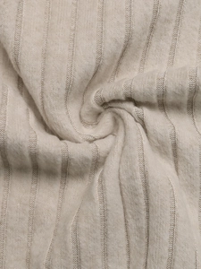 Gros plan sur la texture du tricot côtelé doux blanc cassé pour haut à manches longues
