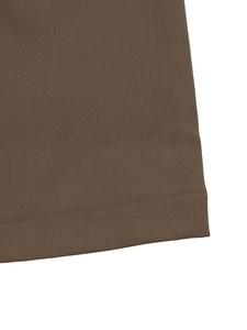 Macro detail of brown twill fabric texture and flat stitched hem on straight trousers