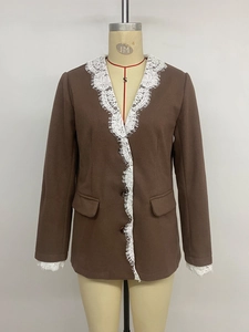Dettaglio del blazer marrone con inserti in pizzo bianco sui polsini e colletto