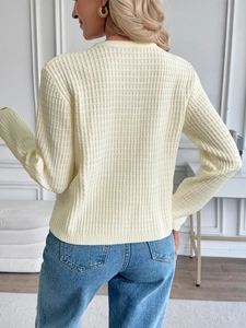 Rear view of light yellow ribbed knit cardigan with elegant metal buttons and soft texture