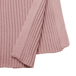 Close-up of pink ribbed knit fabric detail showing the side slit and fine texture