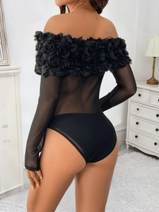 Detail eines schwarzen Mesh-Bodys mit 3D-Blumenapplikationen und schulterfreiem Design