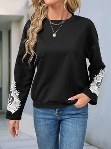Detail of the white floral lace splicing on sleeves of the black crewneck sweatshirt