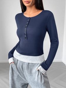 Detail of dark blue contrast faux two-piece top with round neck and decorative buttons
