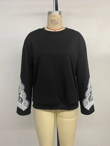 Detail of white lace embroidery on black long sleeve sweatshirt sleeves for women