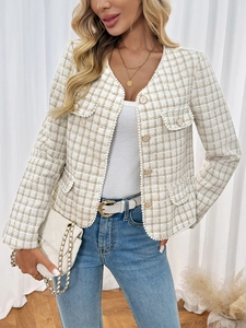Detail of tweed jacket featuring pearl trim, gold buttons and elegant woven texture