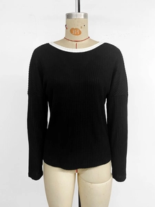 Detail of black ribbed knit long sleeve top with white contrast crew neck and drop shoulder