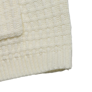 Close-up of cream knit sweater showing chunky waffle texture and ribbed sleeve cuffs