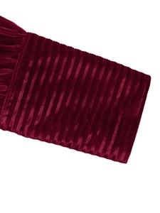 Vue macro de la texture velours rouge foncé avec motifs côtelés sur la manche