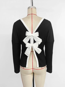 Close-up of black ribbed sweater showing deep V back design with white bows