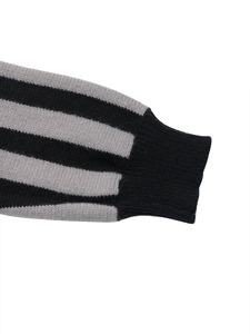 Gros plan des poignets côtelés et des rayures noires et grises du pull en maille