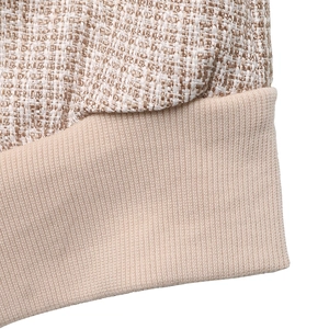 Détail macro du tissu en tweed et de l'ourlet en maille côtelée d'une veste à col baseball