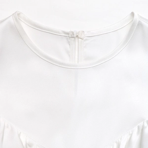 Detail of white satin shirt neckline featuring a round collar and back button closure
