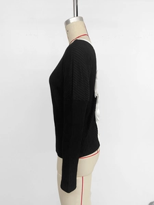 Detail of black ribbed knit sweater featuring delicate white 3D bow accents on the back
