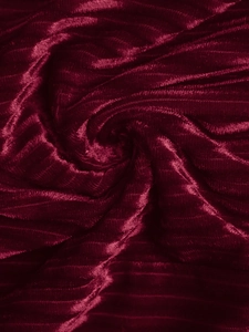 Gros plan sur le tissu en velours rouge foncé avec une texture rayée et un éclat élégant