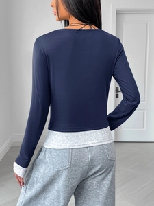 Detail of the back view showing navy slim-fit layered long sleeve tee with grey patchwork hem