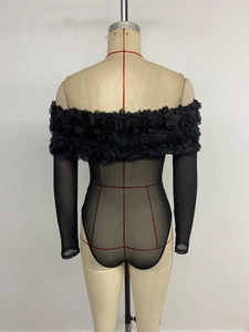 Detail der 3D-Blumenverzierungen an einem durchsichtigen schwarzen Bodysuit