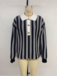 Détail du pull en maille rayé avec col polo blanc et boutons en bois de qualité