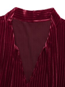 Détail de la robe en velours bordeaux avec texture plissée et empiècement en mesh