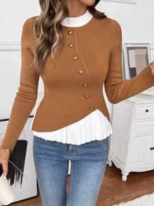 Detail of knit sweater with gold buttons and asymmetrical white pleated hemline