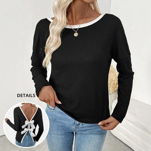 Slim fit black ribbed knit long sleeve top featuring a deep V-back with white bows