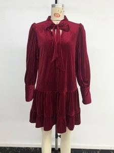 Détail de la robe en velours bordeaux avec plis verticaux et jupe à volants étagés