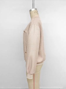Détail d'une veste en tweed rose et blanc avec poche boutonnée et poignets côtelés