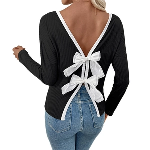 Women's ribbed black long sleeve top featuring backless V-neck design with white bows