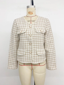 Close-up of elegant tweed cardigan with pearl trim and classic textured knit finish