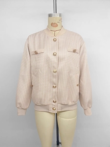 Détail de la veste en tweed avec tissage rose et beige et boutons dorés gaufrés