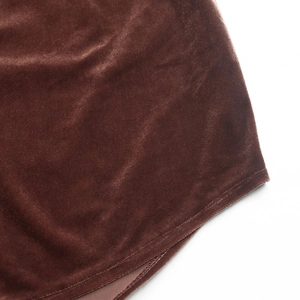 Detail shot of deep brown velvet fabric texture with precise edge stitching and soft sheen