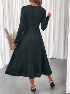 Detailed back view of dark green ribbed long sleeve midi dress with flared skirt